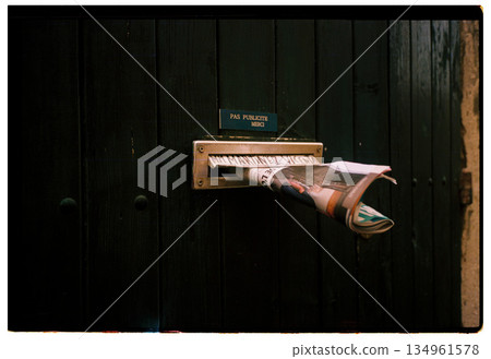 Rolled newspaper in door slot on analog film Rolled newspaper in door slot on analog film 134961578