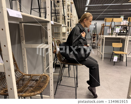 Woman sitting on stool in furniture store 134961915