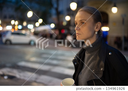 Woman standing on street holding cup 134961926
