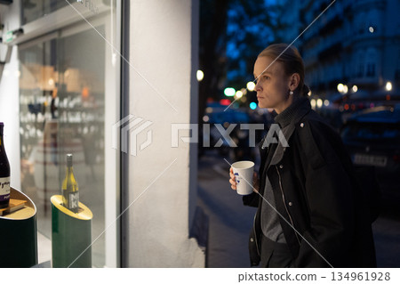 Woman drinking coffee and window shopping Woman drinking coffee and window shopping 134961928