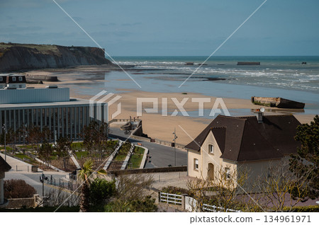 A wide scenic view of Arromanches-les-Bains, France, showcasing the town and its historic beach. This D-Day landing site is now a peaceful coastal destination rich with World War II history. 134961971
