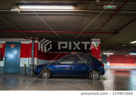 Worn-out blue car with deflated tires in underground garage Worn-out blue car with deflated tires in underground garage 134961988