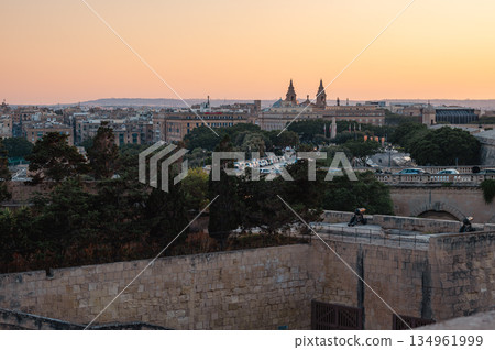 A stunning panoramic view of Birgu Port as seen from a Valletta vantage point, showcasing historic architecture, docked boats, and the scenic Maltese coastline. 134961999