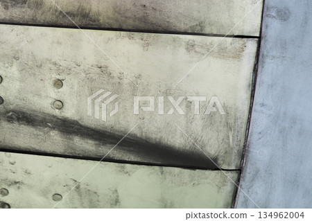 Close view of metallic aircraft skin with rivet lines 134962004