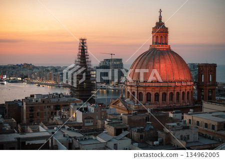 A stunning aerial view of Valletta's rooftops, showcasing the city's historic architecture, domes, and limestone buildings under the Mediterranean sky. 134962005
