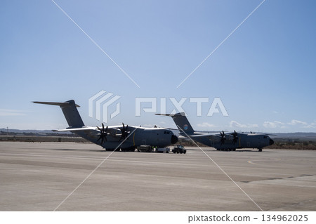 Two military transport aircraft parked on apron at airbase Two military transport aircraft parked on apron at airbase 134962025
