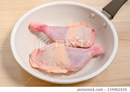 Uncooked bone-in chicken in a frying pan Uncooked bone-in chicken in a frying pan 134962836