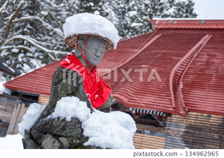Jizo statue wearing a snow hat and a red apron Jizo statue wearing a snow hat and a red apron 134962965