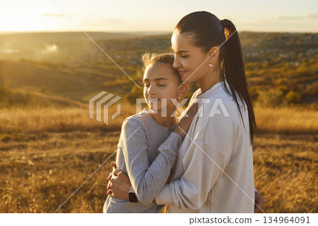 Mother Embracing Daughter During Nature Walk On Mother Day Celebration 134964091