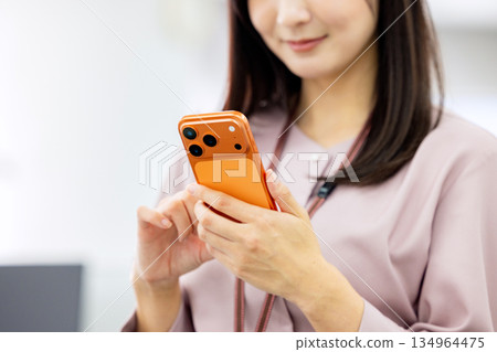 Business woman operating a smartphone Business woman operating a smartphone 134964475