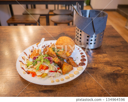 [波蘭] 克拉科夫市中心一家餐廳的餐桌上，盤子裡盛著薯條和沙拉。 134964596