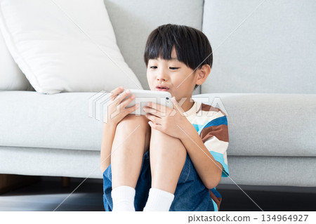 小學生在客廳玩智慧型手機 134964927