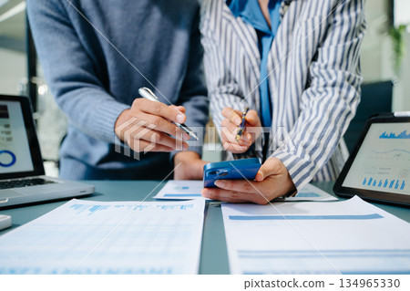 Team business meeting presentation. Hand businessman working project in modern office.Laptop computer and tablet and smart phone on white desk Team business meeting presentation. Hand businessman working project in modern office.Laptop computer and tablet and smart phone on white desk 134965330