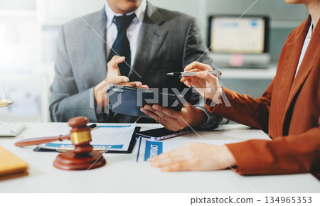 Lawyer consulting client with legal documents and scales of justice on desk. Concept of law, contract, consultation, and professional legal service. 134965353