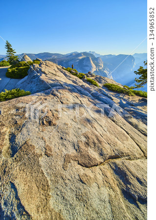 Glacier Point Granite Outcrop with Half Dome and Hikers in Yosemite National Park Glacier Point Granite Outcrop with Half Dome and Hikers in Yosemite National Park 134965852