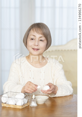 Senior woman eating boiled eggs Senior woman eating boiled eggs 134966270