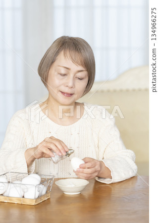 Senior woman eating boiled eggs Senior woman eating boiled eggs 134966275