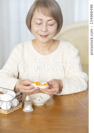 一位老婦人正在吃水煮蛋,畫面模糊。 一位老婦人正在吃水煮蛋,畫面模糊。 134966496
