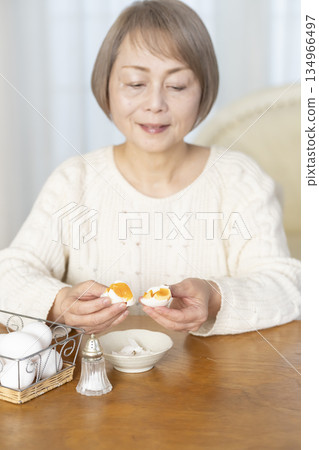 一位老婦人正在吃水煮蛋,畫面模糊。 一位老婦人正在吃水煮蛋,畫面模糊。 134966497