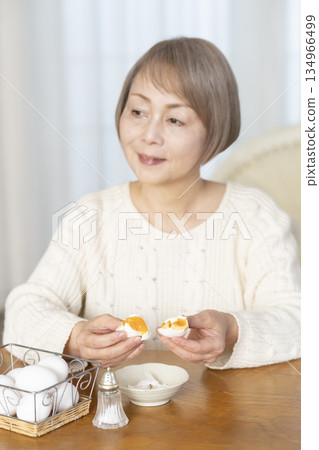 一位老婦人正在吃水煮蛋，畫面模糊。 134966499