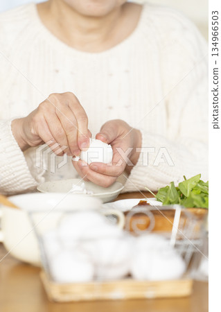 一位老婦人正在吃水煮蛋,畫面模糊。 一位老婦人正在吃水煮蛋,畫面模糊。 134966503