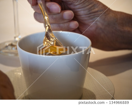 An elderly man's hands enjoying apple tea on a leisurely afternoon 134966889