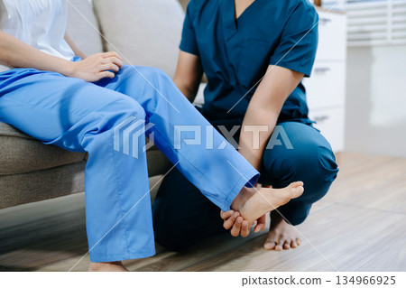Healthcare professional assisting patient with leg physiotherapy treatment, showing injury recovery, rehabilitation Healthcare professional assisting patient with leg physiotherapy treatment, showing injury recovery, rehabilitation 134966925