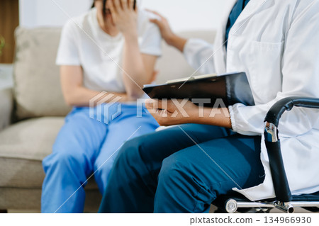 Doctor comforting patient with pain and stress during consultation, showing healthcare, empathy, support, and professional medical care. 134966930