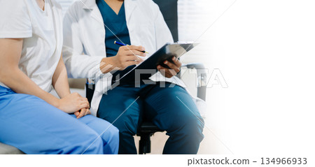 Doctor consulting with patient using clipboard, showing professional healthcare communication, diagnosis, and medical treatment discussion. Doctor consulting with patient using clipboard, showing professional healthcare communication, diagnosis, and medical treatment discussion. 134966933