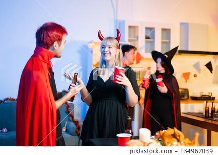 Joyful office Halloween party with coworkers in costumes, celebrating with drinks and laughter, fostering teamwork and festive spirit Joyful office Halloween party with coworkers in costumes, celebrating with drinks and laughter, fostering teamwork and festive spirit 134967039