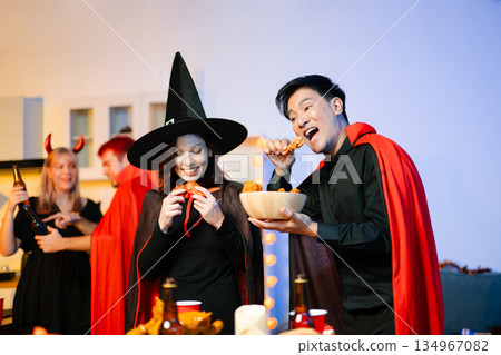 Joyful office Halloween party with coworkers in costumes, celebrating with drinks and laughter, fostering teamwork and festive spirit 134967082