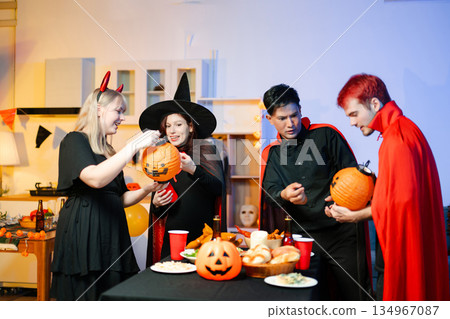 Joyful office Halloween party with coworkers in costumes, celebrating with drinks and laughter, fostering teamwork and festive spirit 134967087