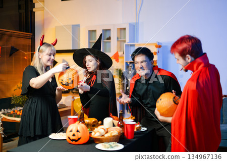 Joyful office Halloween party with coworkers in costumes, celebrating with drinks and laughter, fostering teamwork and festive spirit 134967136