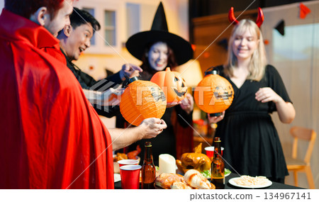 Joyful office Halloween party with coworkers in costumes, celebrating with drinks and laughter, fostering teamwork and festive spirit 134967141