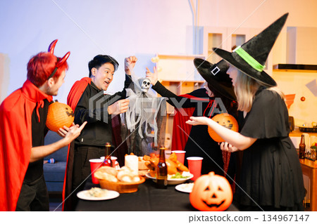 Joyful office Halloween party with coworkers in costumes, celebrating with drinks and laughter, fostering teamwork and festive spirit 134967147