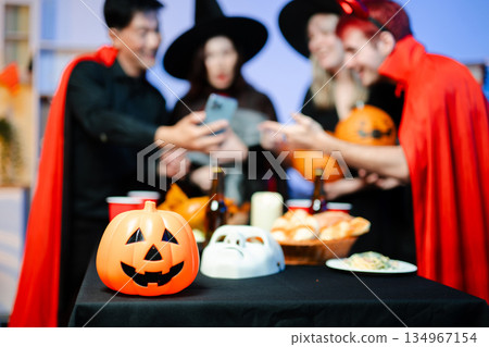 Joyful office Halloween party with coworkers in costumes, celebrating with drinks and laughter, fostering teamwork and festive spirit 134967154