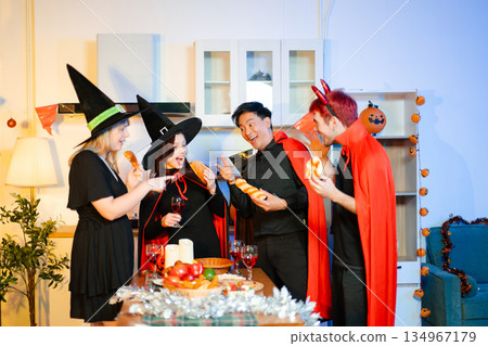 Halloween party react with surprise and laughter to spooky props like pumpkins and a ghost skeleton. Perfect seasonal fun, decor, and festive vibes. Halloween party react with surprise and laughter to spooky props like pumpkins and a ghost skeleton. Perfect seasonal fun, decor, and festive vibes. 134967179
