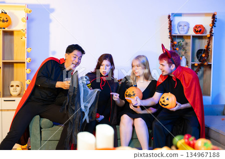 Joyful office Halloween party with coworkers in costumes, celebrating with drinks and laughter, fostering teamwork and festive spirit Joyful office Halloween party with coworkers in costumes, celebrating with drinks and laughter, fostering teamwork and festive spirit 134967188