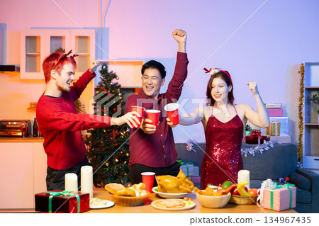 Friends celebrate Christmas with gift exchanges, festive food, and perfect scene for holiday and New Year themes filled with joy and togetherness 134967435