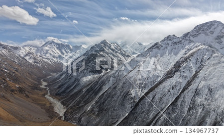 Snow-capped mountains with river flowing through valley landscape Snow-capped mountains with river flowing through valley landscape 134967737