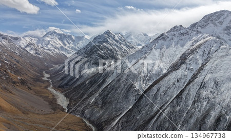Majestic snow-capped mountains with winding river in valley landscape Majestic snow-capped mountains with winding river in valley landscape 134967738