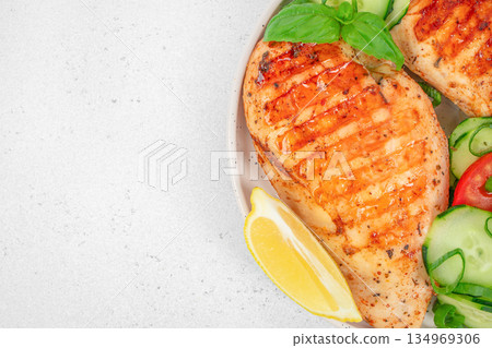 Grilled chicken breast with fresh vegetables and lemon on plate with copy space Grilled chicken breast with fresh vegetables and lemon on plate with copy space 134969306