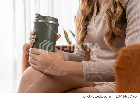 Caucasian woman holding reusable tumbler closeup on hands Caucasian woman holding reusable tumbler closeup on hands 134969750