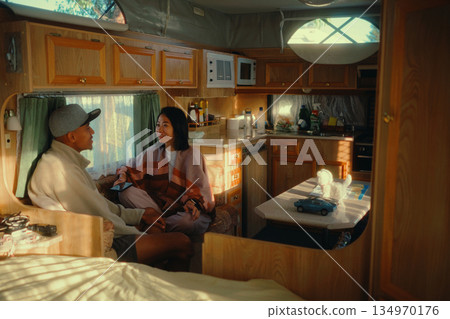 Engaging in a Cozy Conversation Inside of a Vintage Camper Trailer 134970176
