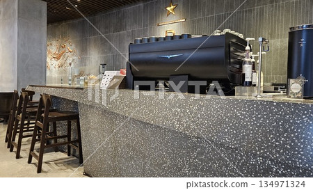 A sleek Starbucks Reserve counter with espresso machines, and holiday merchandise blends premium coffee culture A sleek Starbucks Reserve counter with espresso machines, and holiday merchandise blends premium coffee culture 134971324