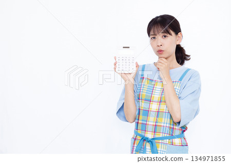A worried housewife holding a calculator A worried housewife holding a calculator 134971855