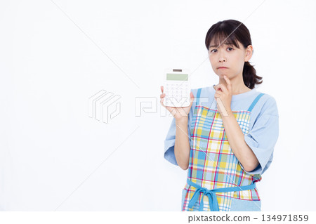 A worried housewife holding a calculator A worried housewife holding a calculator 134971859