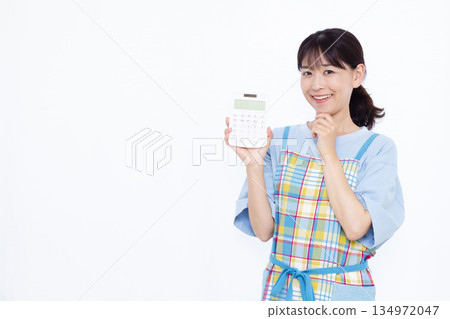 A worried housewife holding a calculator A worried housewife holding a calculator 134972047