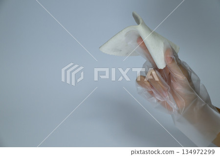 Hands wearing vinyl gloves and wiping with a cloth Hands wearing vinyl gloves and wiping with a cloth 134972299