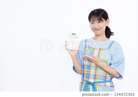 A housewife with a smile holding a calculator A housewife with a smile holding a calculator 134972303